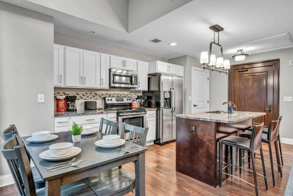 a kitchen with a table and chairs and a kitchen with white cabinets at LUXE Condo Downtown | Security•Gym•Parking in Cleveland