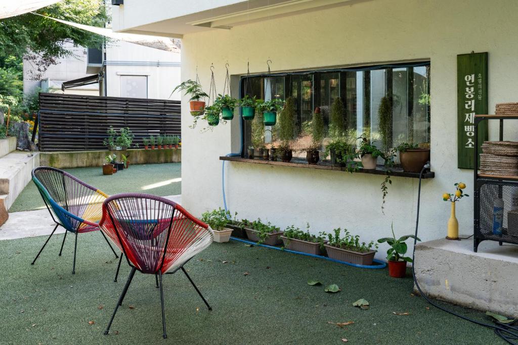 a patio with two chairs and a window with plants at 연봉리 스테이 in Hongcheon
