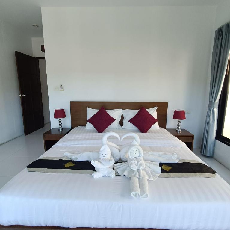 a bedroom with a bed with two angels on it at Nern khao Guesthouse in Kamala Beach