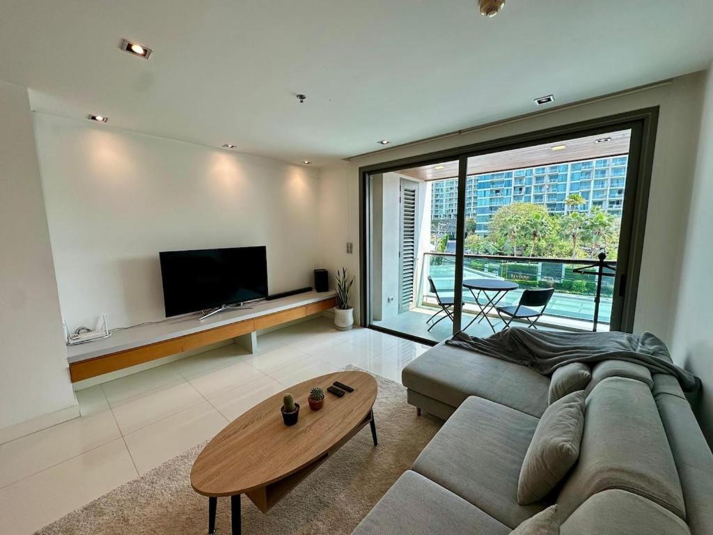 a living room with a couch and a table at Fancy Beachfront Condominium in North Pattaya