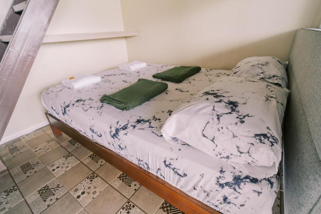 a small bed with two green pillows on it at Serenity Busay Room 6 in Cebu City
