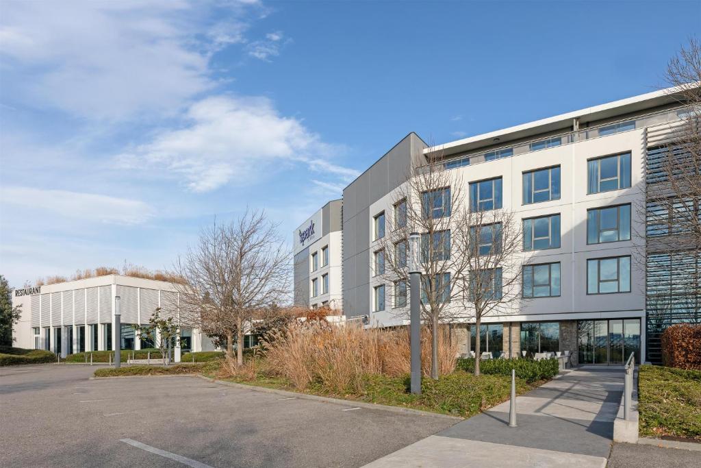 an empty parking lot in front of a building at Spark by Hilton Lyon Eurexpo in Genas