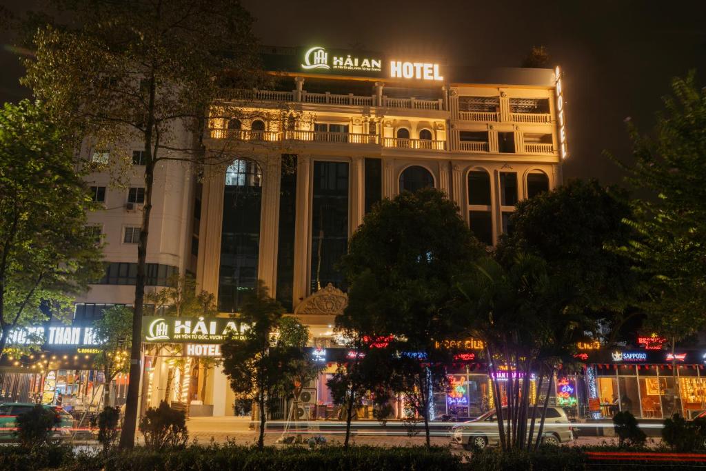 a building with a sign on top of it at night at Hai An Hotel Suites Ha Noi in Hanoi