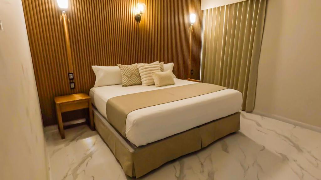 a bedroom with a large white bed with pillows at Hotel JVD Inn - Tonalá Centro GDL in Guadalajara