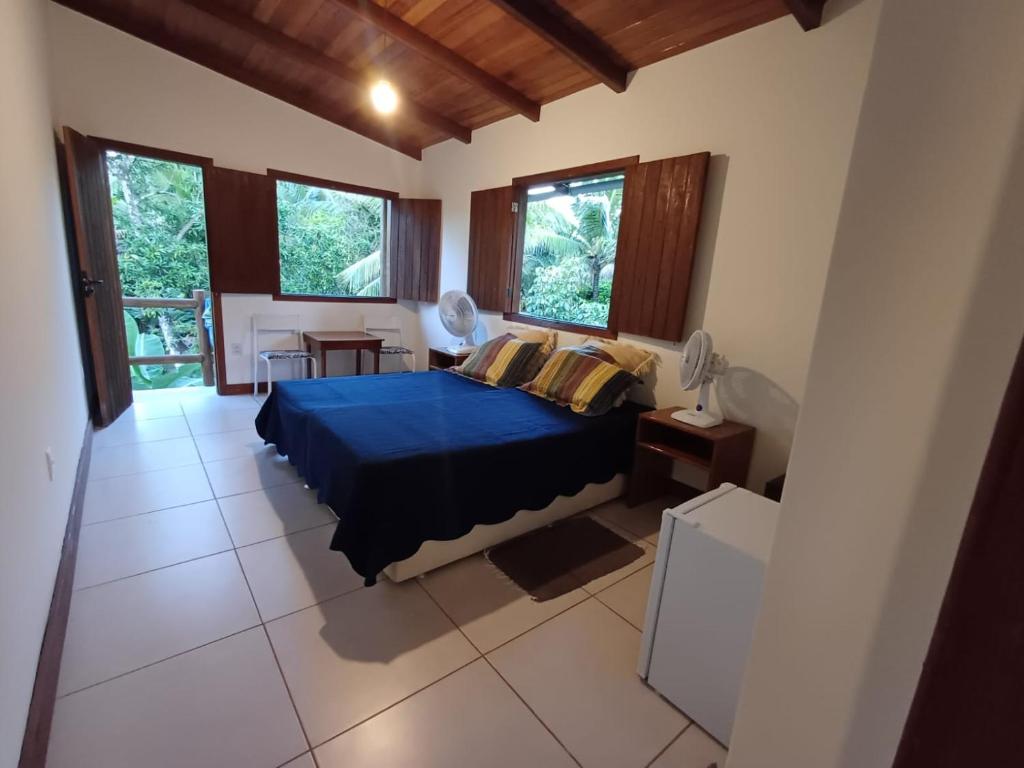 a bedroom with a blue bed and some windows at Suíte Colibri - Centro de Barra Grande in Marau
