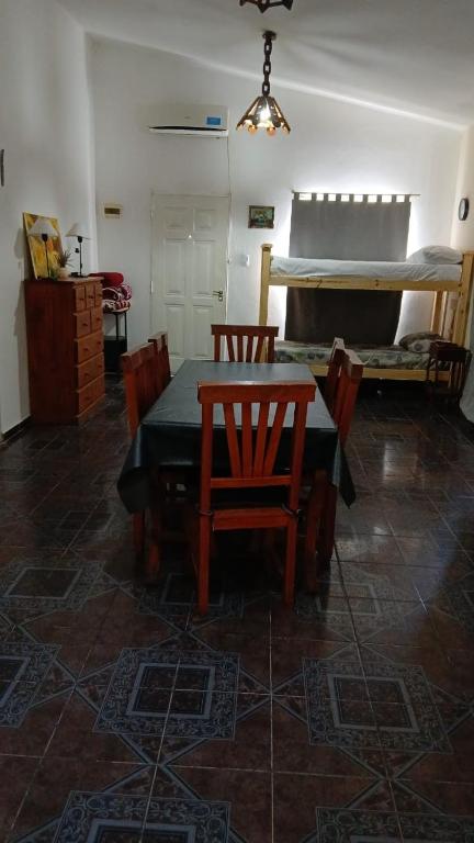 a dining room with a table and chairs and a bed at Cabañas Arelí in Santa María