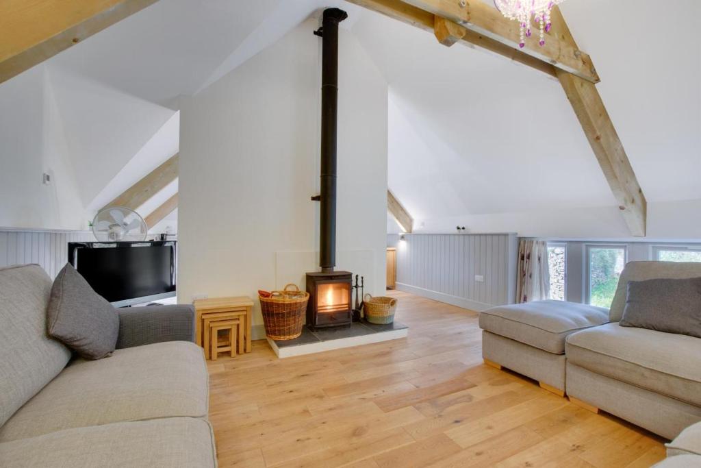 a living room with two couches and a fireplace at 3 Bed in Totnes oc-bcplym in Broadhempston