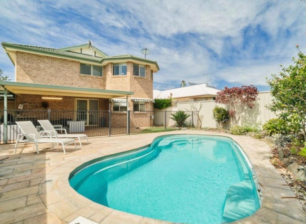 a swimming pool in front of a house at Beach Street Stay in Harrington