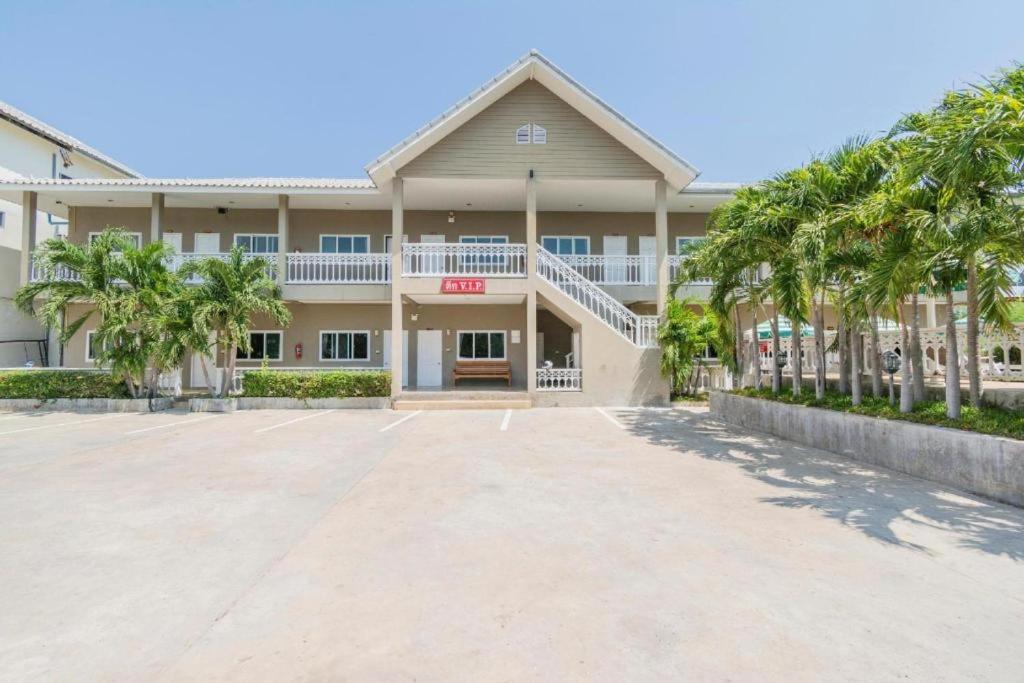 a large building with palm trees in front of it at Blue Horizon in Hua Hin