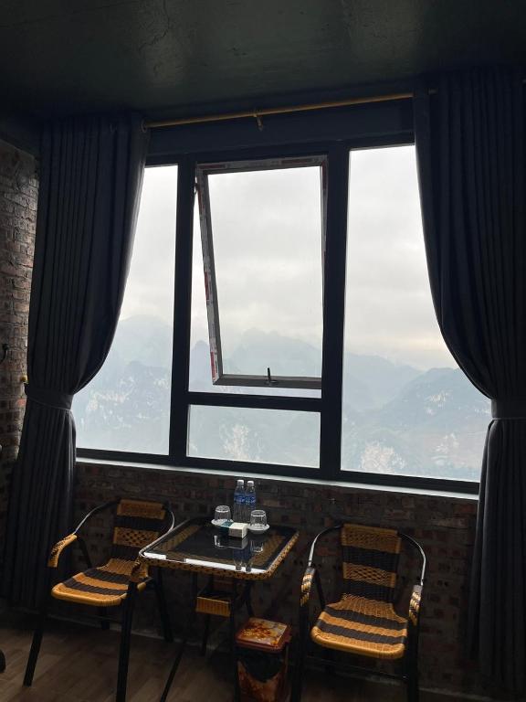 a room with a table and chairs and a large window at Moutain View in Yên Minh