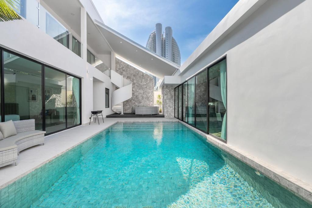 an infinity pool in the backyard of a house at Mövenpick Pool Villa6BR-NEW2025- in Na Jomtien