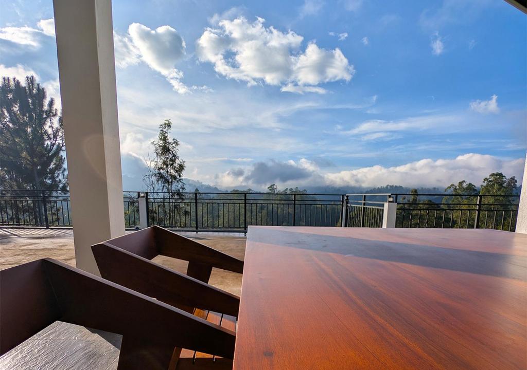 a balcony with a bench and a view of the ocean at Ophelia in Diyatalawa