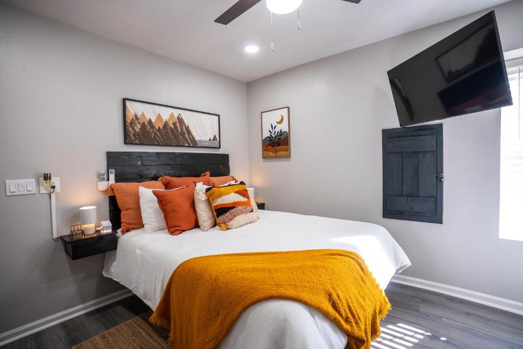 a bedroom with a large white bed with orange pillows at BOHO-MOD STUDIO APARTMENTs in Ferris