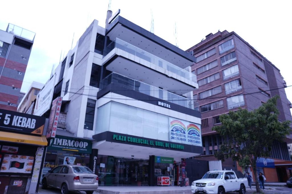 a building on a city street with cars parked in front at Hotel Gool De Guerron in Quito