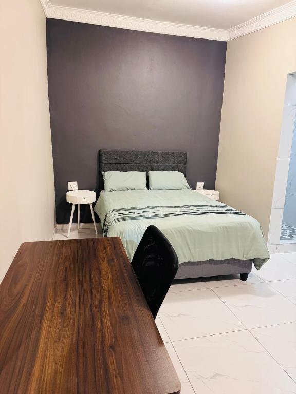 a bedroom with a bed and a wooden table at Pholanathi Lodge in Cliffdale