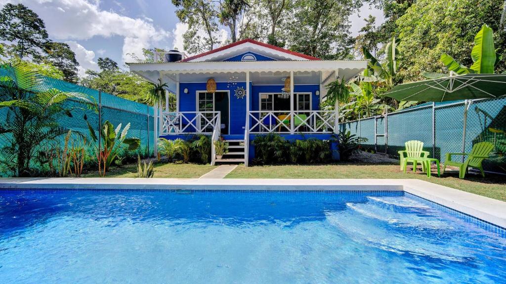 a blue house with a swimming pool in front of it at Casa Caribe Azul - Playa Negra 2BR with AC and pool in Puerto Viejo