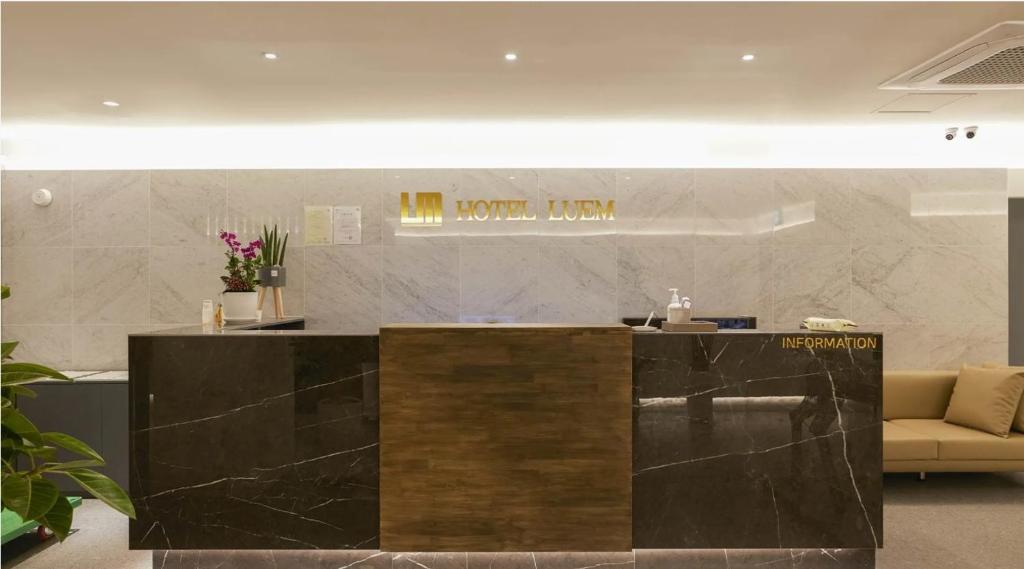 a lobby with a reception desk and a couch at 루엠호텔안산 in Ansan