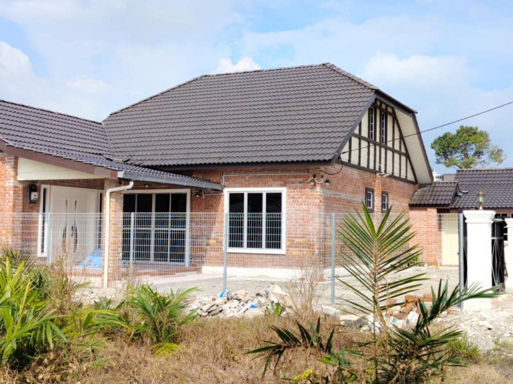 a brick house with a black roof at Dynz Cottage in Banting