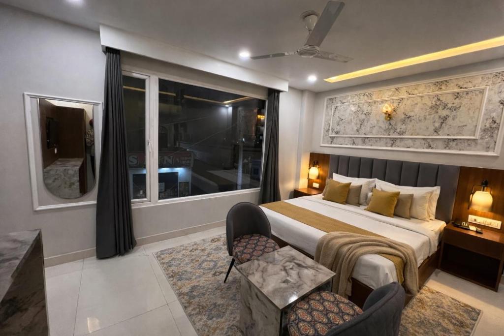 a bedroom with a bed and a large window at Hotel Royal Dot, Haridwar in Haridwār