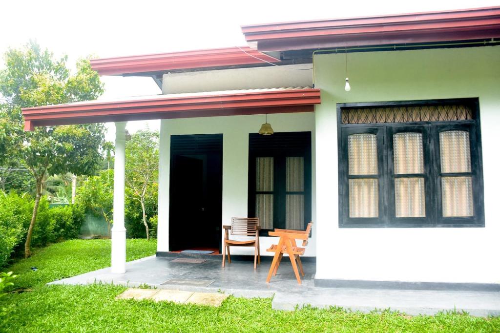 a house with a table and a chair on a patio at Chenudi Villa Ahangama in Ahangama