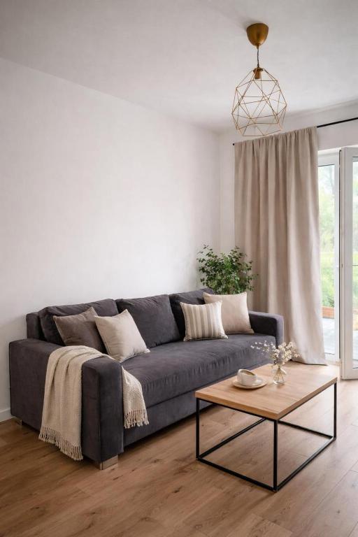 a living room with a blue couch and a table at Apartament z dużym ogródkiem in Rzeszów