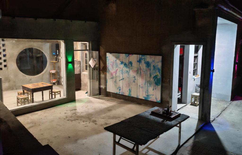 a room with a table and a painting on the wall at 天天绘住 in Xianzong