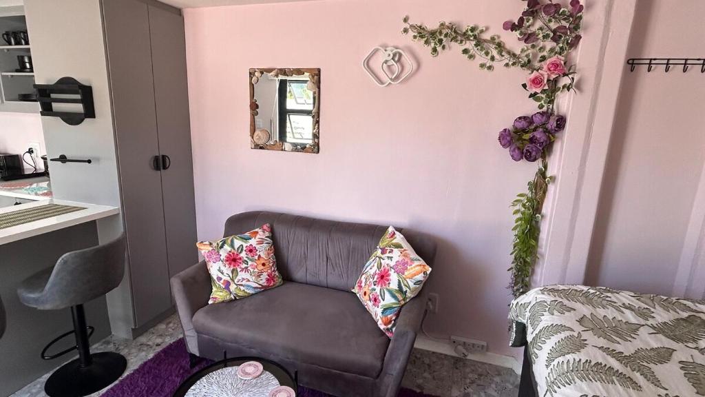 a living room with a couch and a mirror at Marina Dreams Studio Apartment in Marina Da Gama