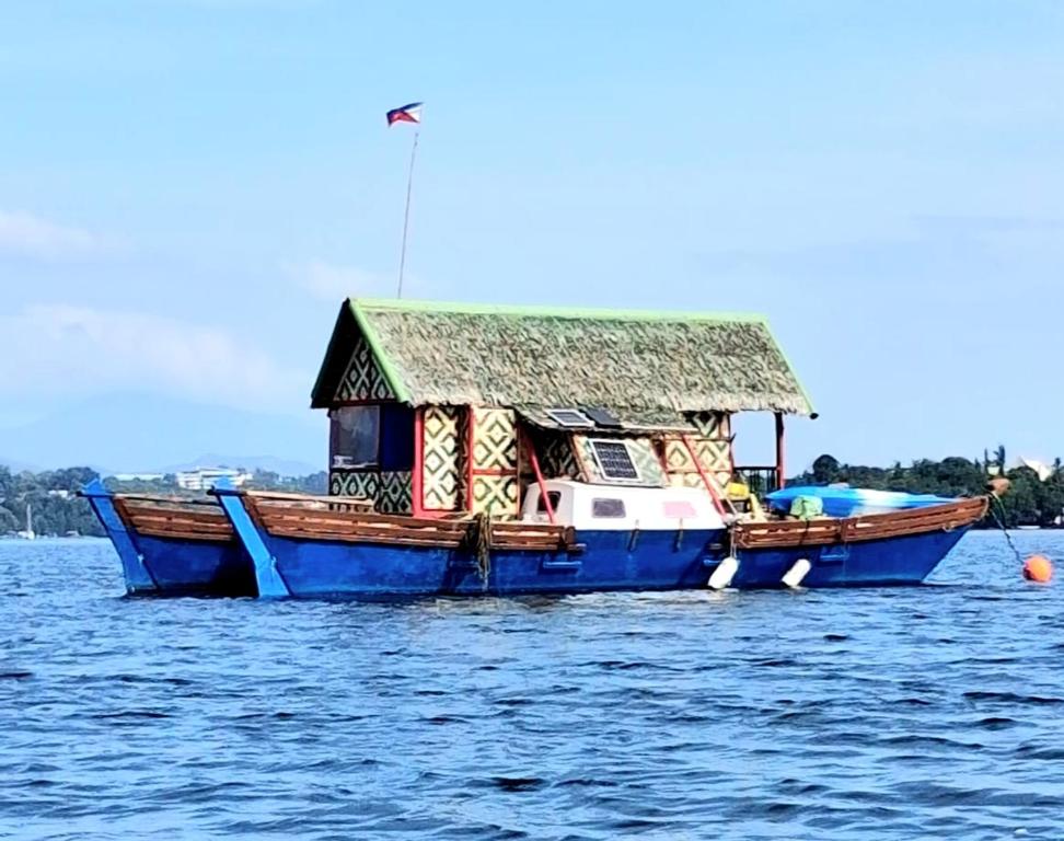 a blue boat with a house on the water at Warram mobile in Puerto Princesa City