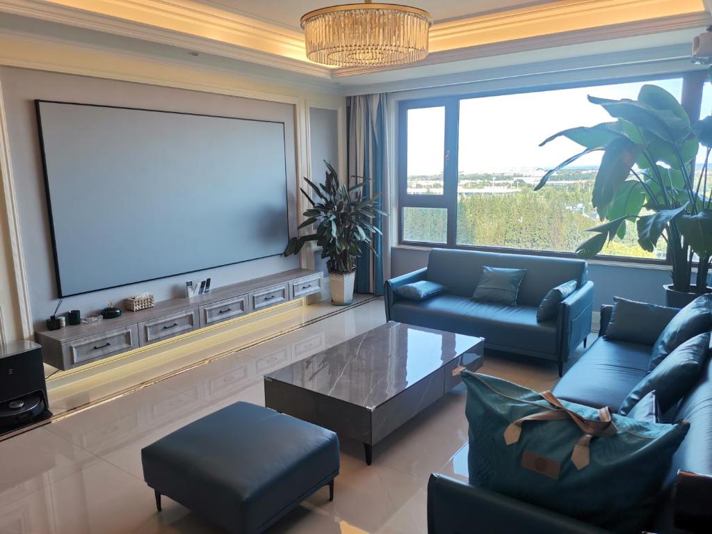 a living room with a large flat screen tv at SeaHear Premier in Rizhao