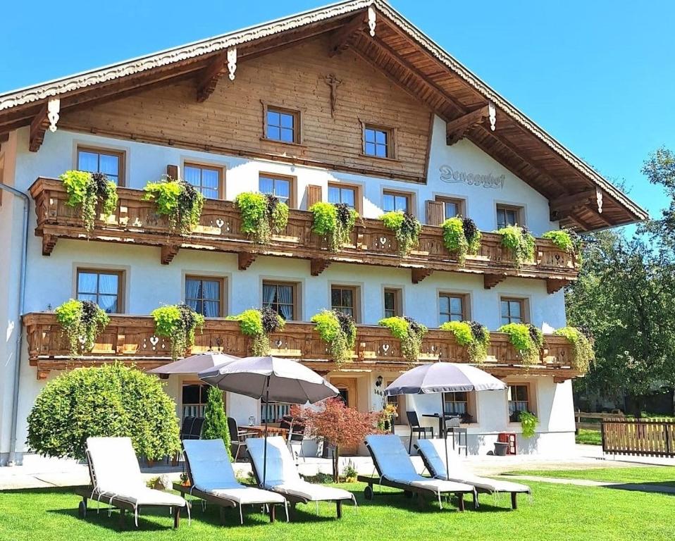 a hotel with chairs and umbrellas in front of it at Denggnhof in Münster
