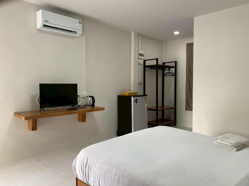 a bedroom with a white bed and a heater at Thip Thip Ressort Ao Nang in Ban Khlong Haeng