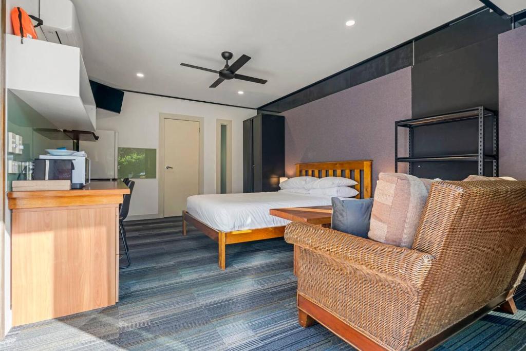 a bedroom with a bed and a couch and a chair at McLaren Flat Studio in McLaren Flat