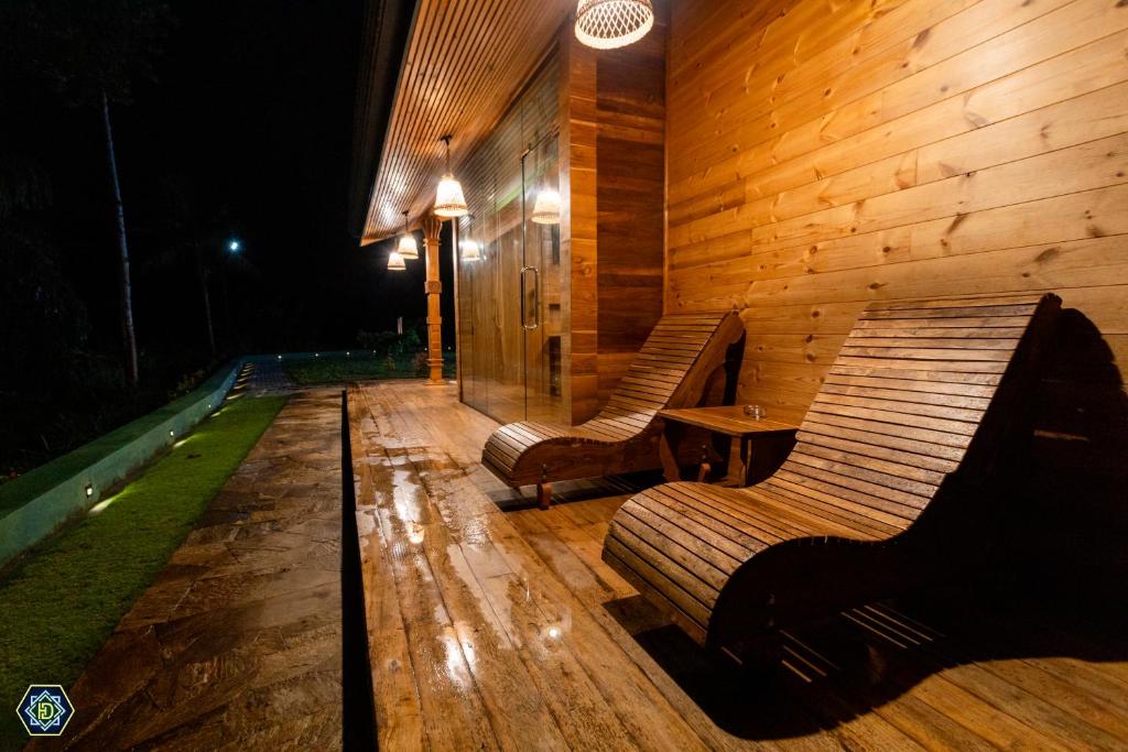 two benches on a wooden deck at night at Hotel Narangala Wooden Villa in Badulla