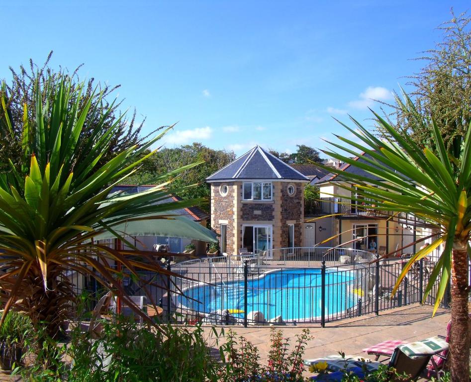 a house with a swimming pool in front of a house at Porth Veor Manor Villas & Apartments in Newquay