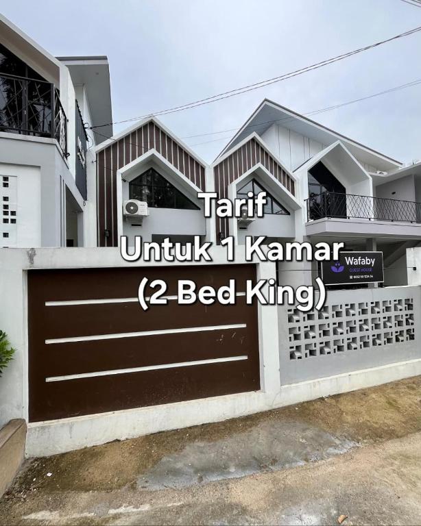 a house with a gate in front of it at Wafaby Guest House in Payakumbuh