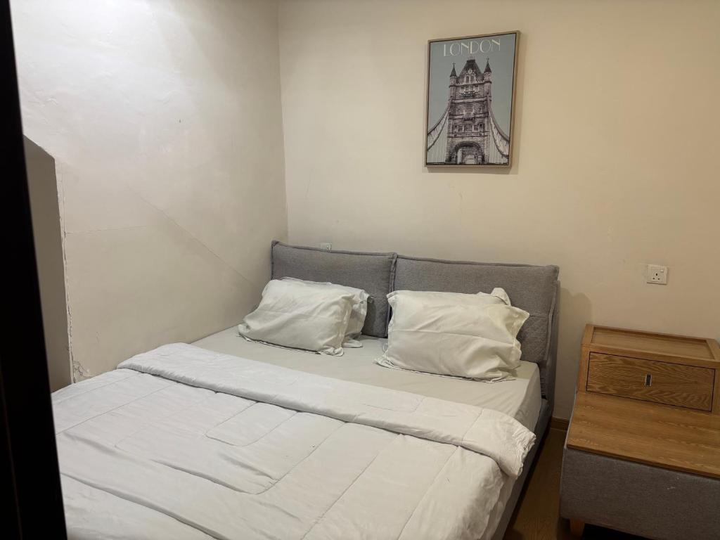 a bed with two pillows and a picture of the eiffel tower at Casanova Penuin Batam in Nagoya