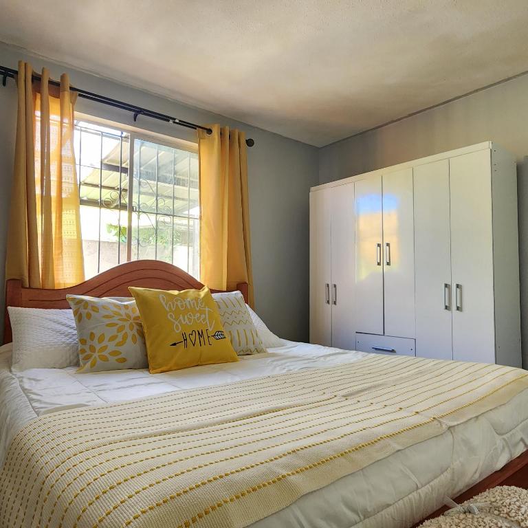 a bedroom with a large bed with yellow and white pillows at Casa Runa in Quillota