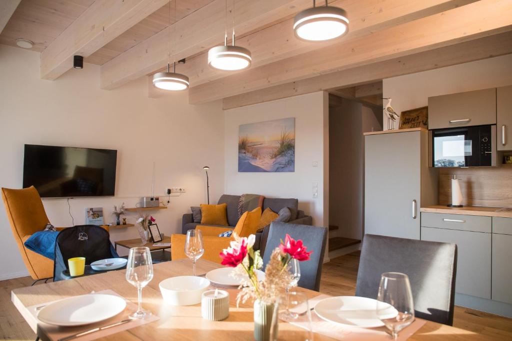 a dining room and living room with a table and chairs at Gulfhof Wangermeer 1 Lotta in Hohenkirchen