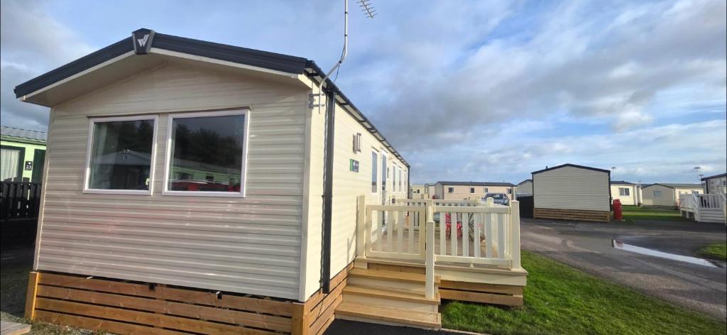 a tiny house sitting on the side of a street at T&K's Caravan in Morecambe