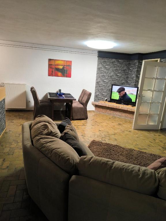 a person laying on a couch in a living room with a tv at Ferienwohnung Viktoria in Ehrlich