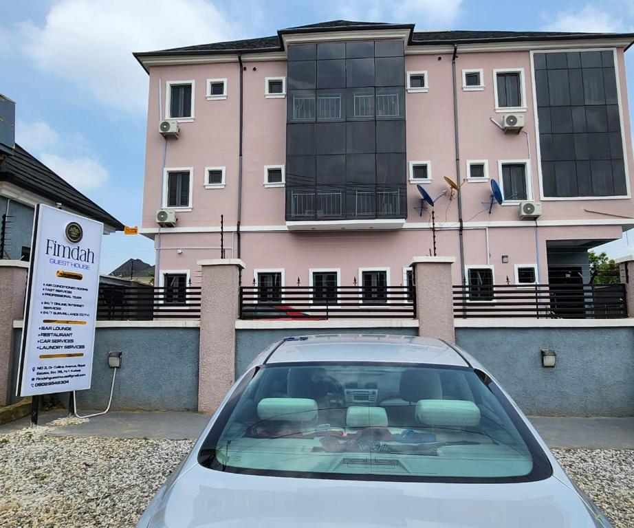 a car parked in front of a pink building at Fimdah Hotel in Dushepe