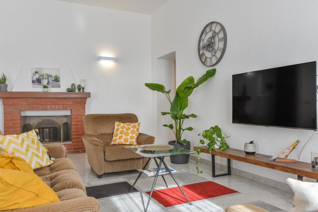 a living room with a couch and a tv on a wall at A Casa di Nonna Anna in Porto Azzurro