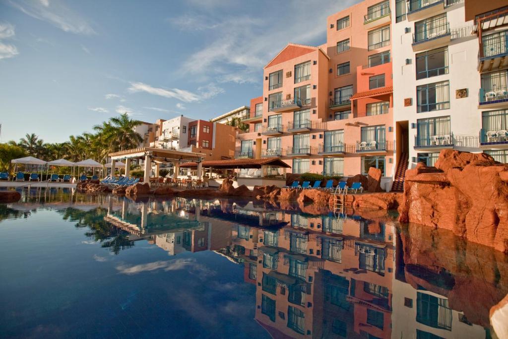 a reflection of buildings in a body of water at El Cid Marina Beach Hotel in Mazatlán