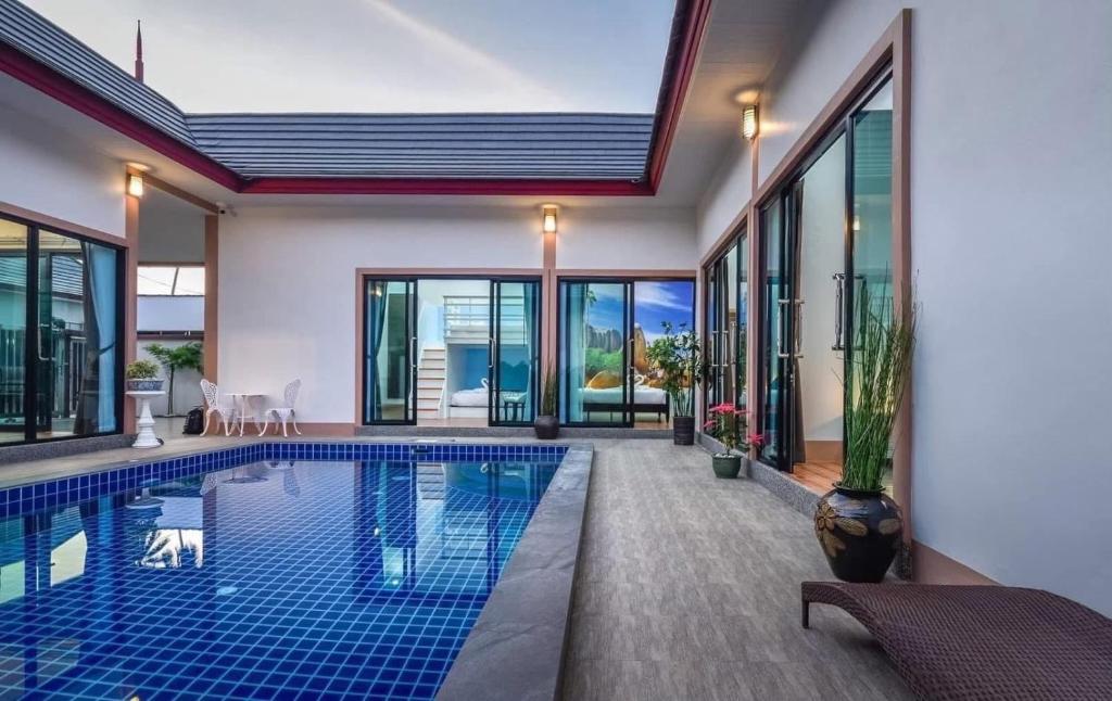 a swimming pool in a house with glass windows at Cocoloco Pool Villa Ao Nang in Ao Nang 