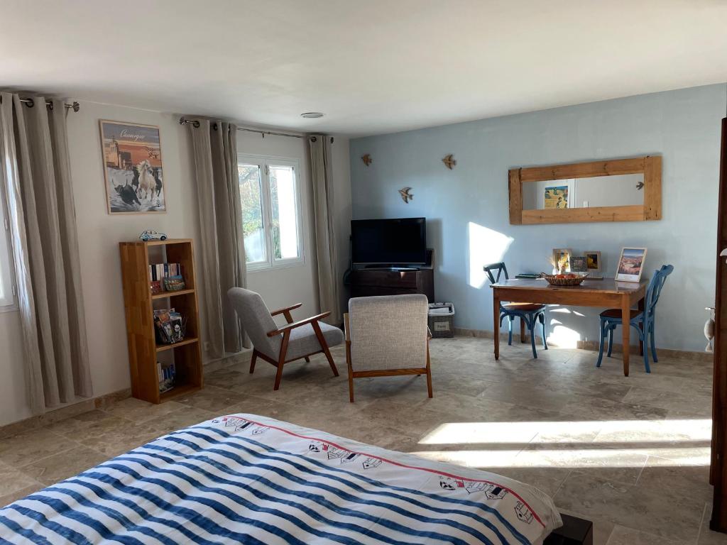 a bedroom with a bed and a table and chairs at ARLES CAMPAGNE LOCATION "La Campagn'Arles" in Arles