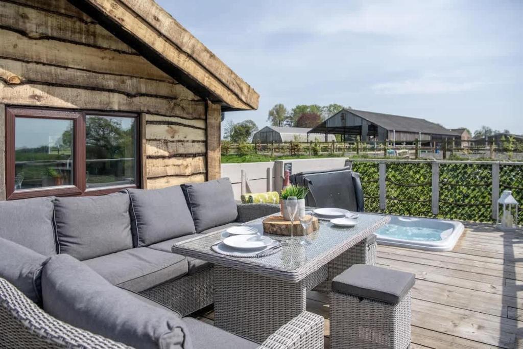 a patio with a couch and a table on a deck at Tesseyman Lodge in Bubwith
