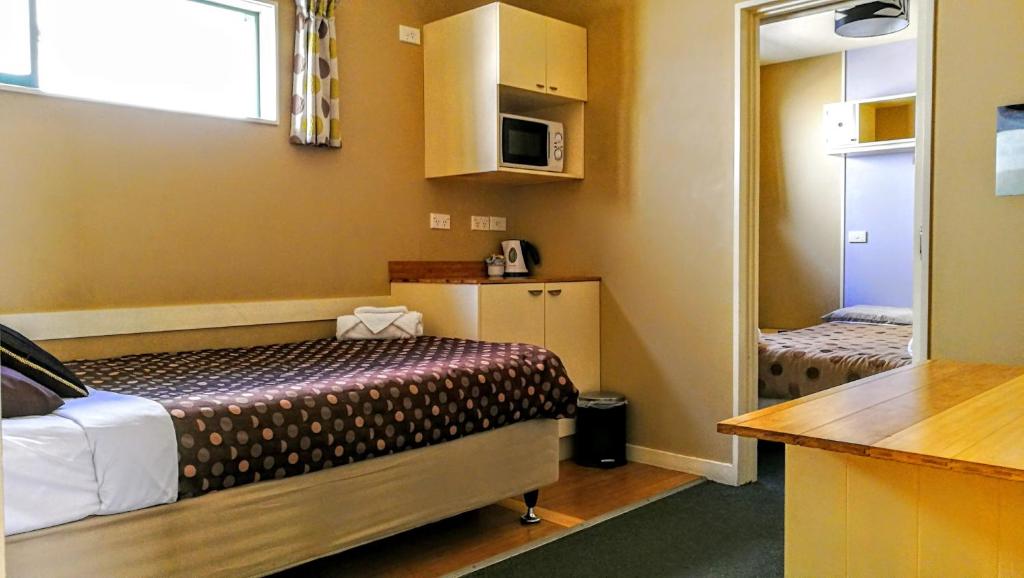 a hotel room with a bed and a desk at Astray Motel & Backpackers Rotorua in Rotorua
