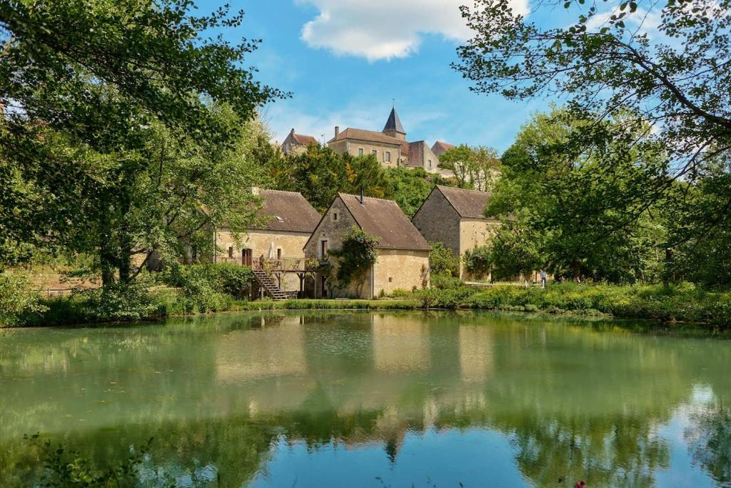 a view of a river with a castle in the background at Water Mill - Private Lake - Fiber Wifi - Burgundy in Rix