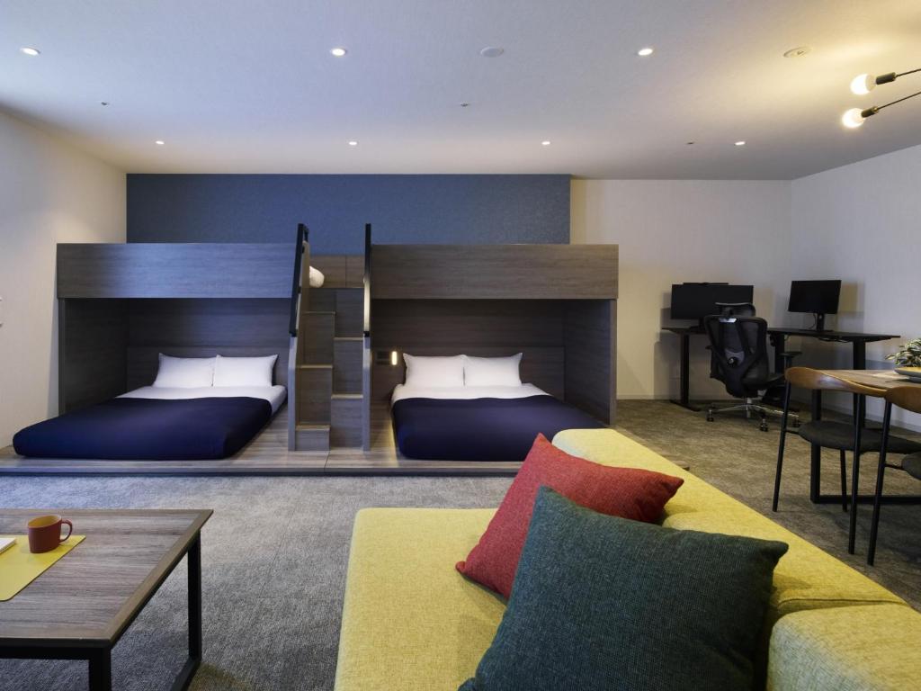 a hotel room with two beds and a couch at Minn STATION Ai Nagoya in Aoichō