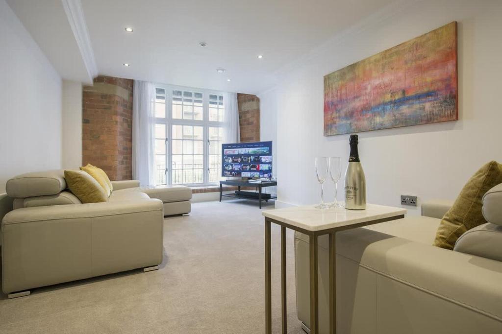 a living room with a couch and a tv at ChocoLets - The Lion Suite in York